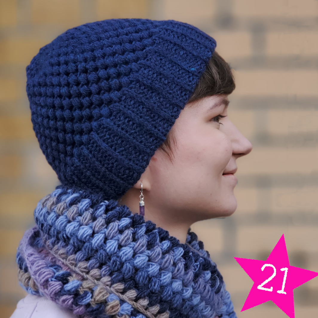 Modell trägt blaue Häkelmütze mit Rippenbündchen